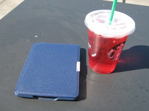 An e-reader and iced ta.